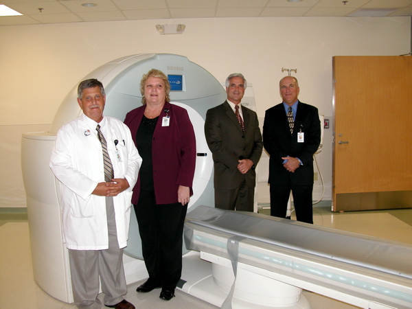A bigger opening for patients and the ability to make finer images are two of the advantages this 64-slice CT scanner offers. Posing with the machine, from left: Norman Godgrey, imaging OPS manager; Theresa Grifith, director of radiology; Delray Medical CEO Robert Kreiger and Delray Medical Chief Operating Officer Jeffrey M. Welch. 