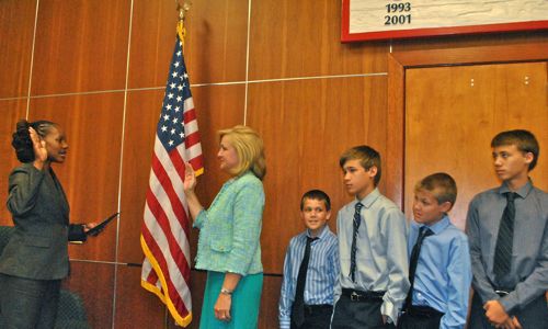 New Commissioner Shelly Petrolia takes the oath while her four sons look on. 